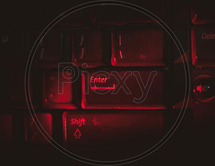 Red Light Is Highlighting On Keyboard'S Enter Button In Dark .