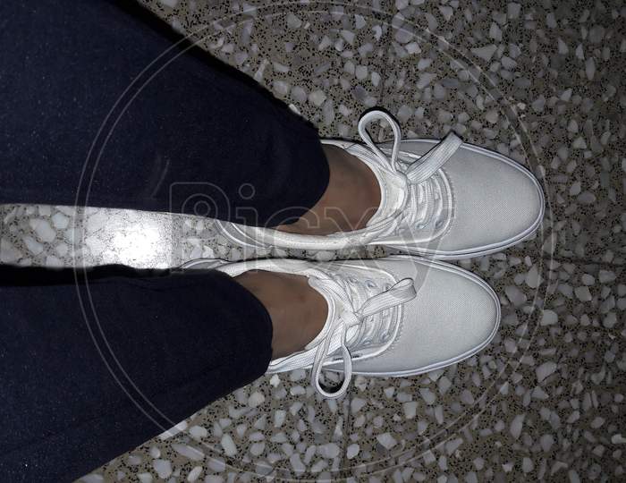 A Pair Of White Shoes With Matching Laces