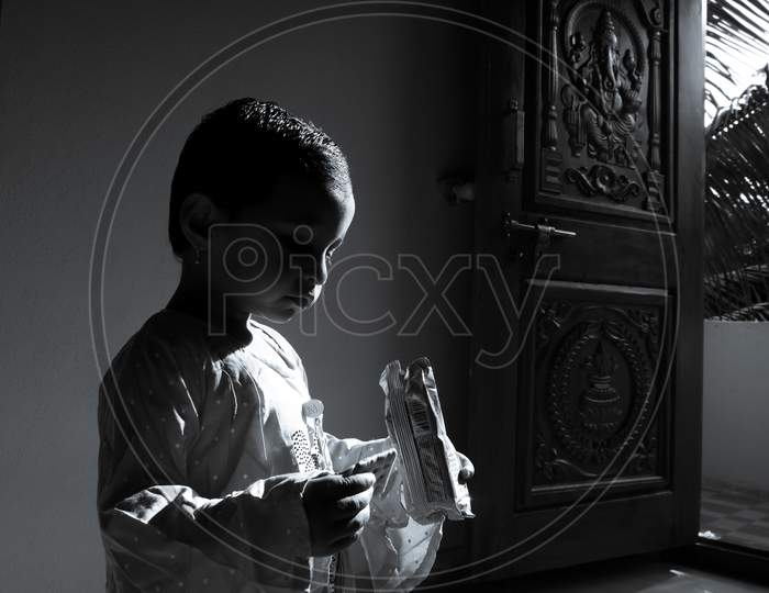 Kalaburagi, Karncloseup Shot Of Girl Child Enjoying Eating Biscuits In Morning Sunlight