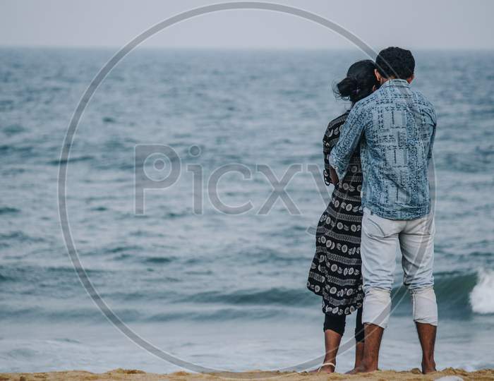 Back View Of A Couple Cuddling At The Beach