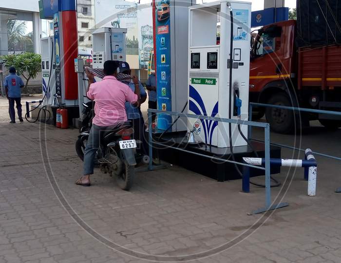 man at petrol pump with his vehicle