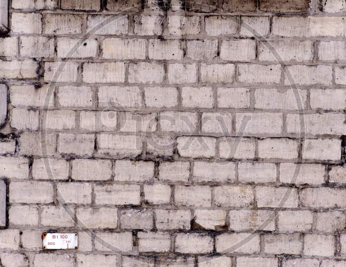 A Wall Made Up Of Grey Bricks And An Ancient Look With Black Color Splashes