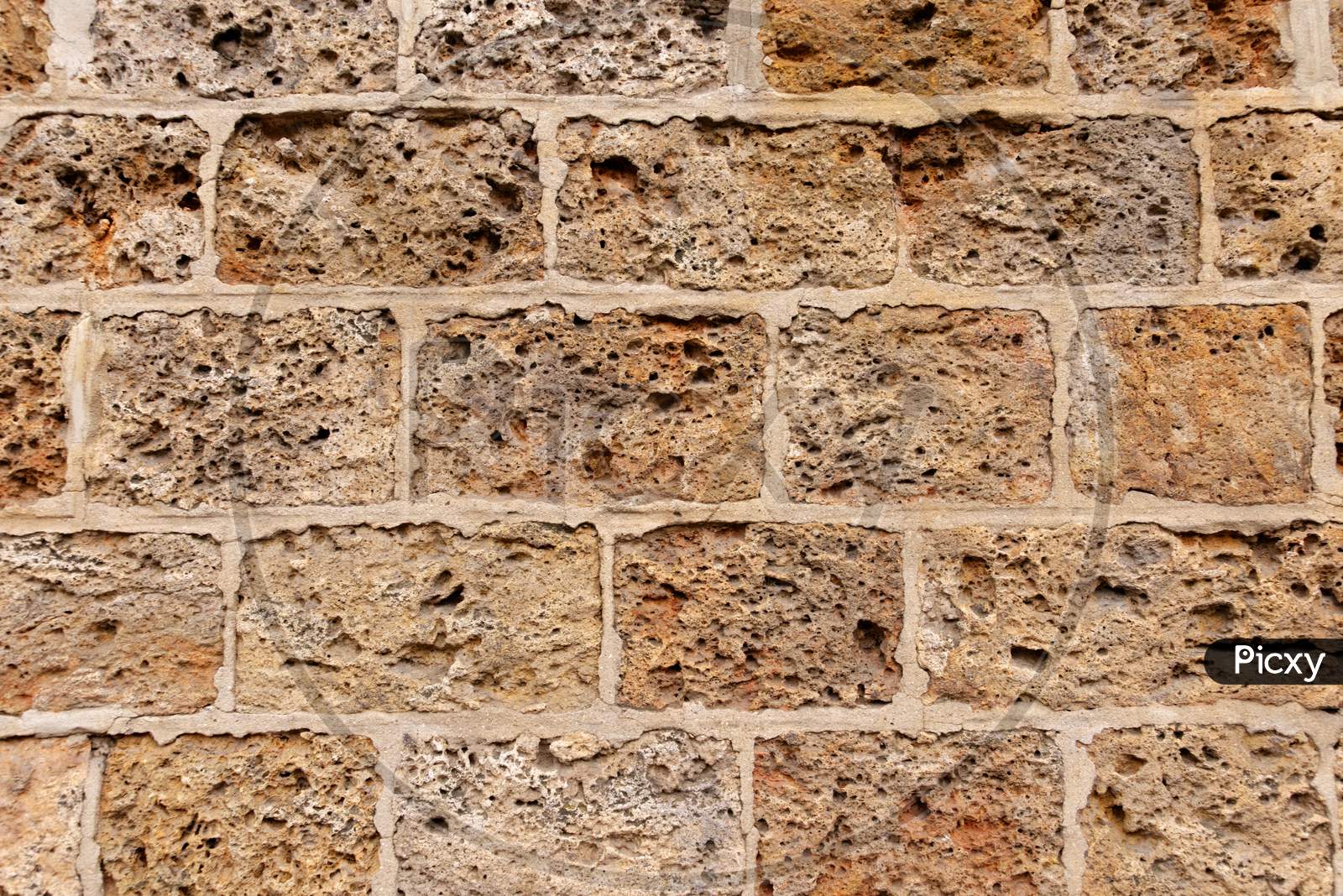 A Wall Formed By Spongy Textured Bricks Attached With Cement Solution