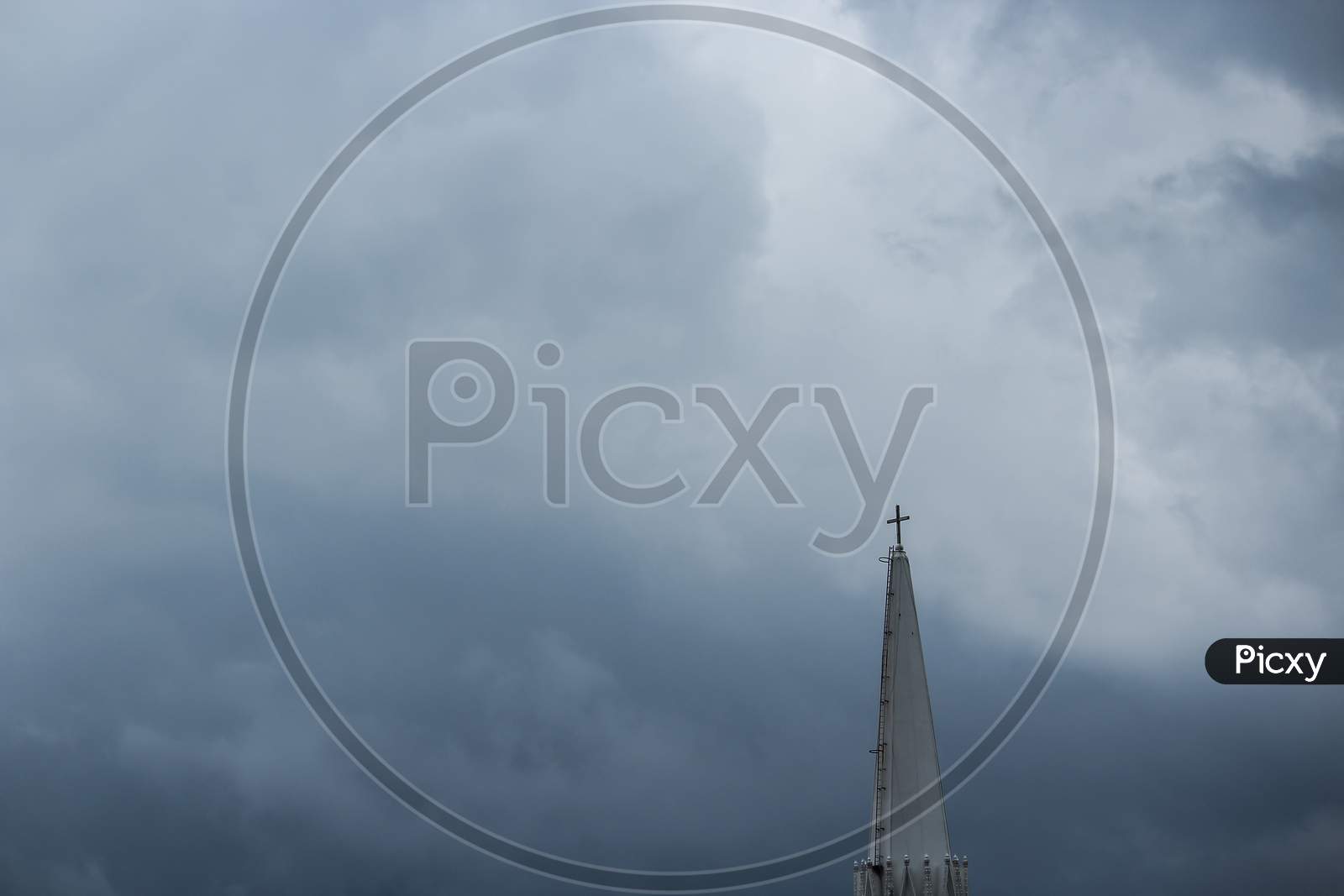 The Top Of A Church Under A Cloudy Sky