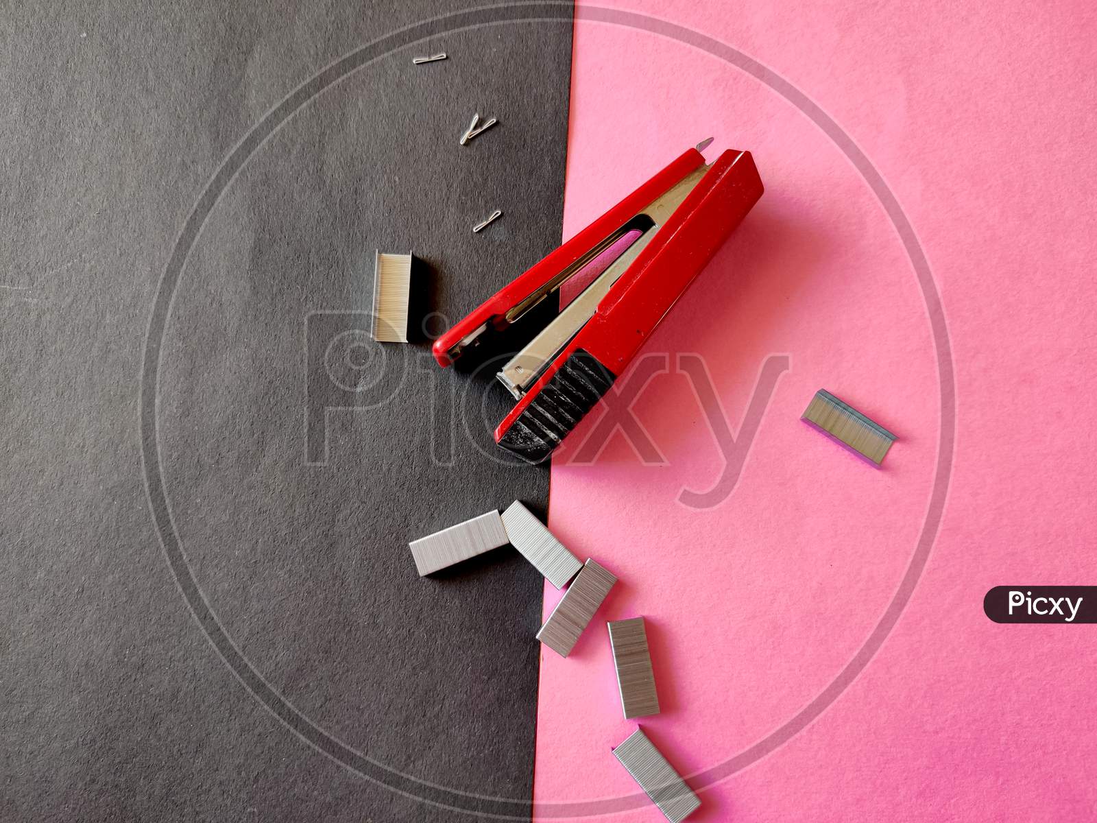 Top View Of Red Color Stapler And Pile Of Stapler Pins Isolated On Pink Background