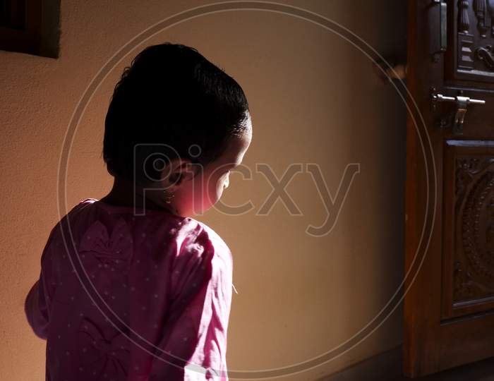 Closeup Shot Of Girl Child In Morning Sunlight In House
