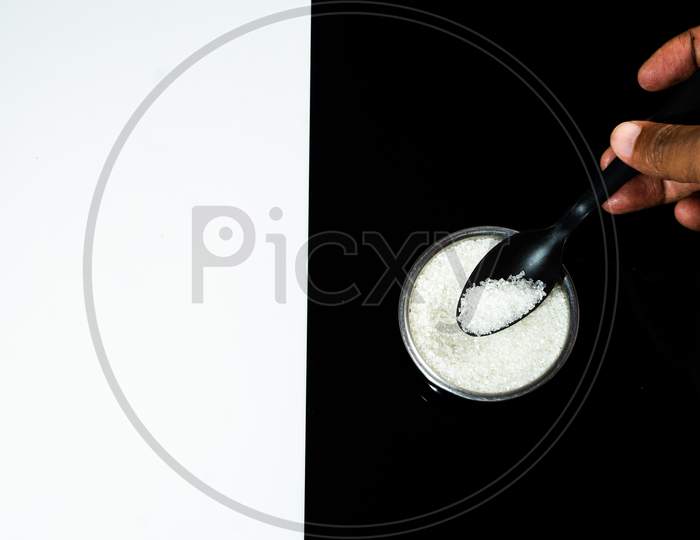 Sugar And Spoon Kept In A Small Bowl With Human Hand