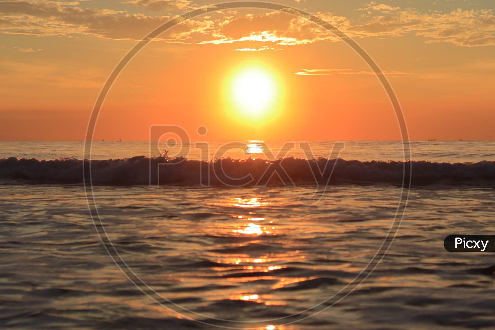 At Sunrise In The Morning, The Huge Bright Rays Of The Bright Sun Welcoming The Rising Waves Of The Huge Ocean