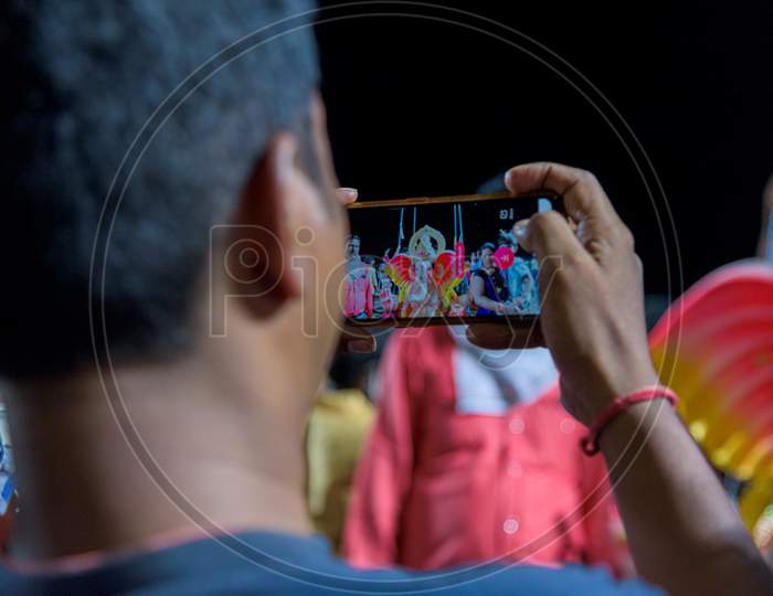 People taking pictures of ganesh immersion in their mobiles at tank bund hyderabad during covid 19 pandemic