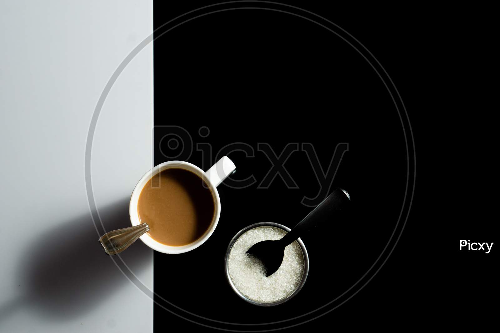 A Cup Of Tea And Sugar On A Black And White Background