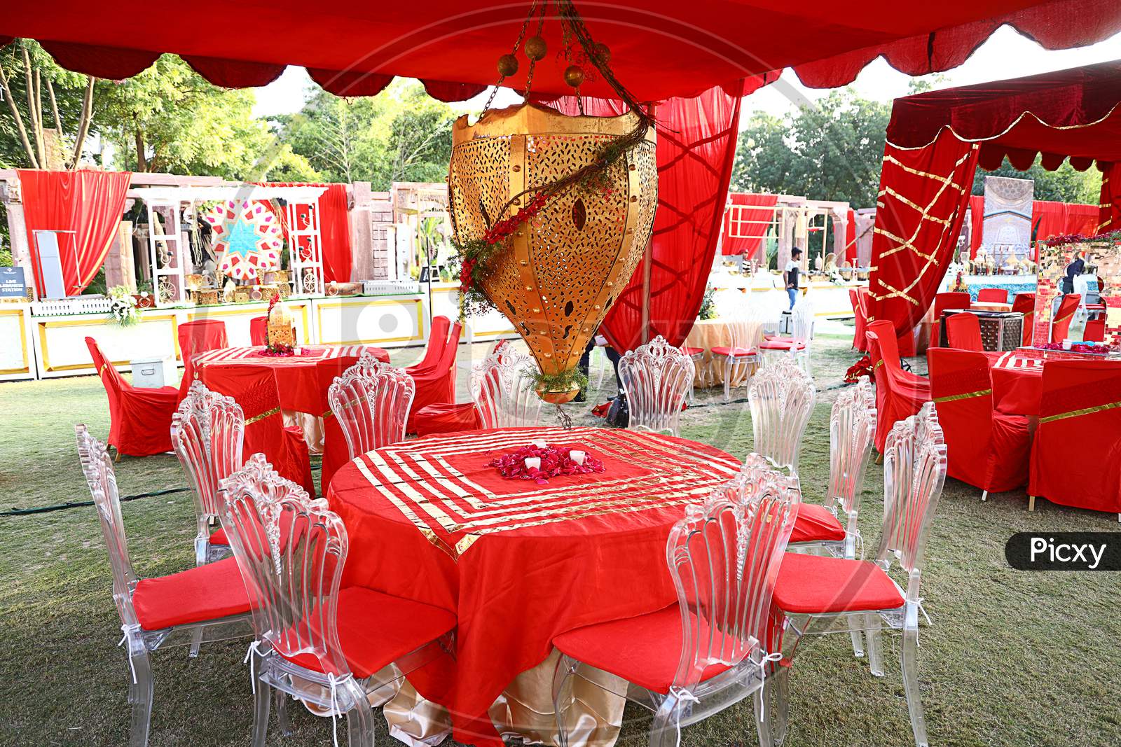 Jodhpur, Rajasthan, India, August 20Th, 2020: Organized Luxury Decorated Round Red Dinner Tables With Hanging Golden Bell At Beautifully Decorated Backyard, Wedding Event Decor Concept