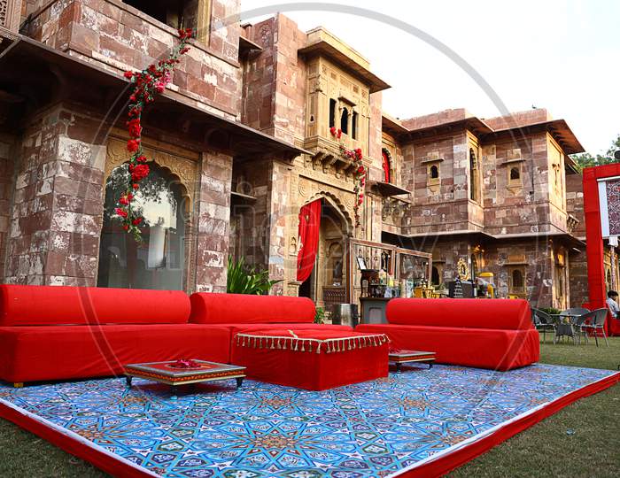 Jodhpur, Rajasthan, India, August 20Th, 2020: Luxury Wedding Destination Decorated With Red Sofas Or Couches And Flowers In Indian Palace Backyard, Wedding Event Decor Concept