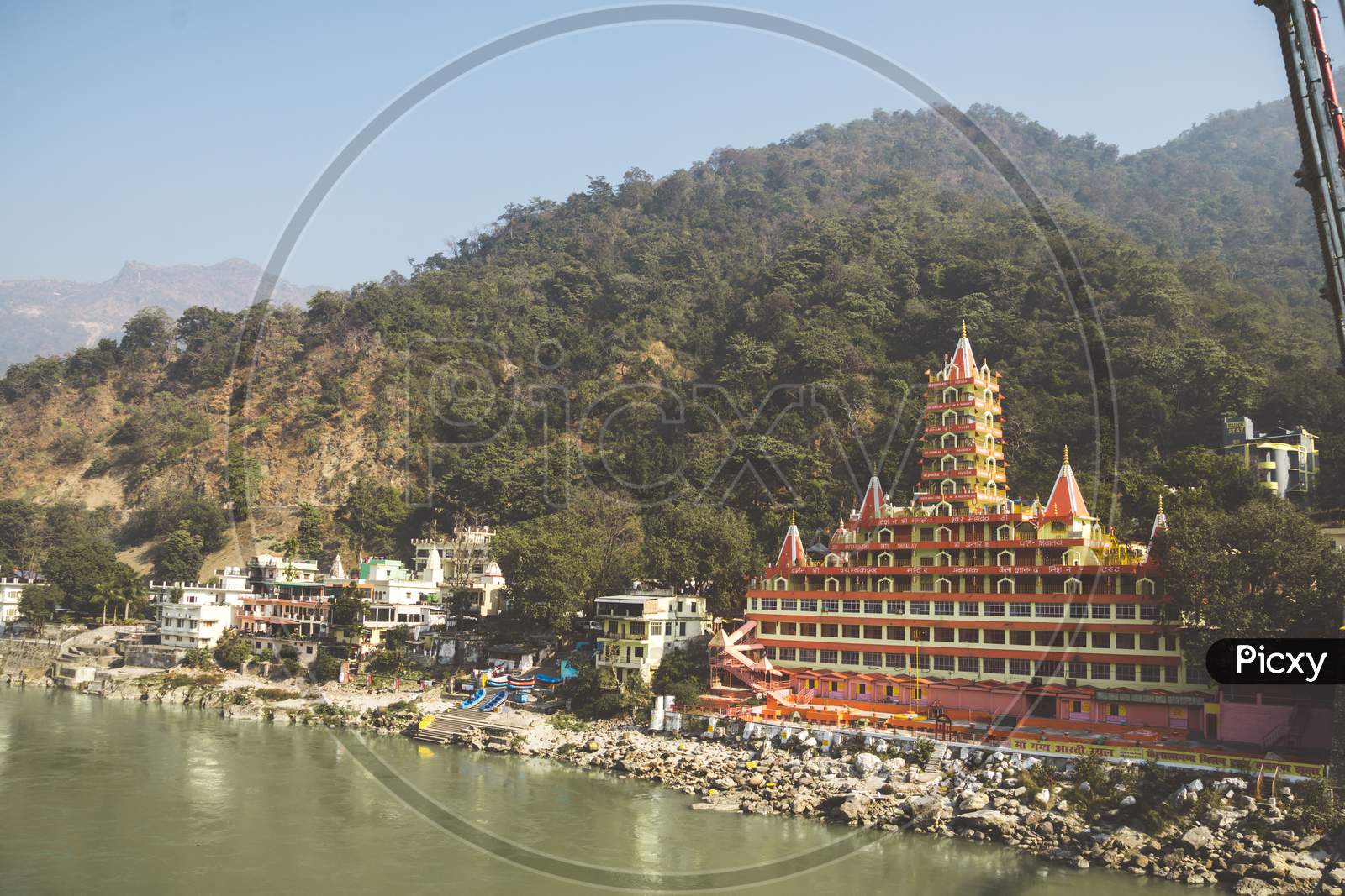 Rishikesh India. 10 January 2018. View Of Ganga River Embankment, Lakshman Jhula Bridge And Tera Manzil Temple, Trimbakeshwar In Rishikesh.