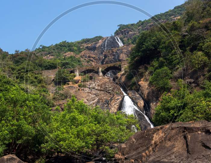 Waterfall In The Mountains Among The Green Trees In The Jungle. Goa