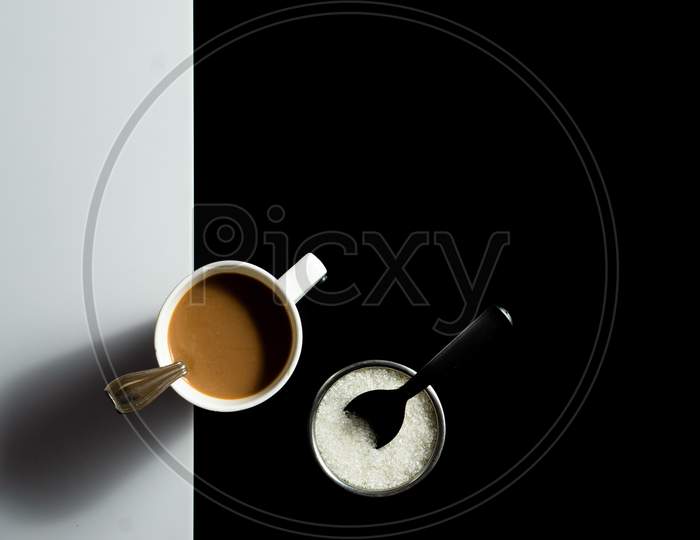 A Cup Of Tea And Sugar On A Black And White Background