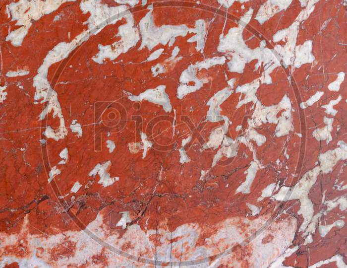 A Ruined Marble Wall With Some Red Paint Splash Over It