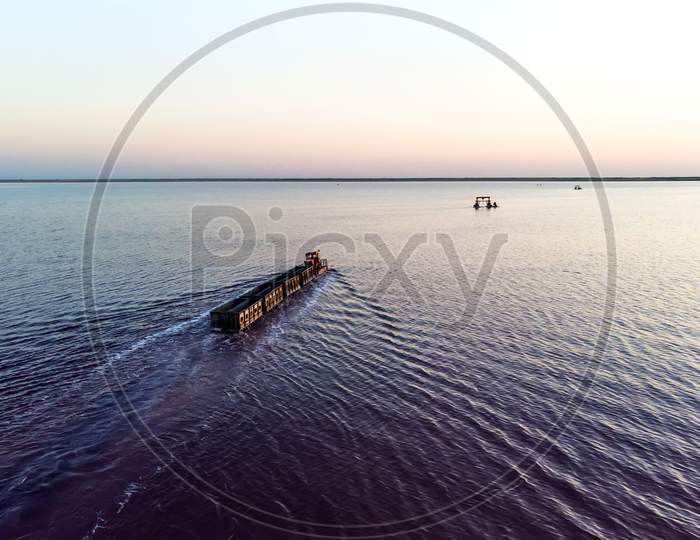 Train Travels From Water. Mined Salt In Lake Burlin. Altai. Russia. Bursolith. Old Train Rides On The Railway Laid In The Water Through The Salt Lake. Aerial View, View From The Top