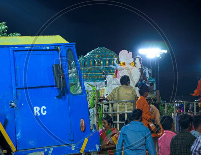 People taking ganesh idol in a vehicle for immersion in tank bund