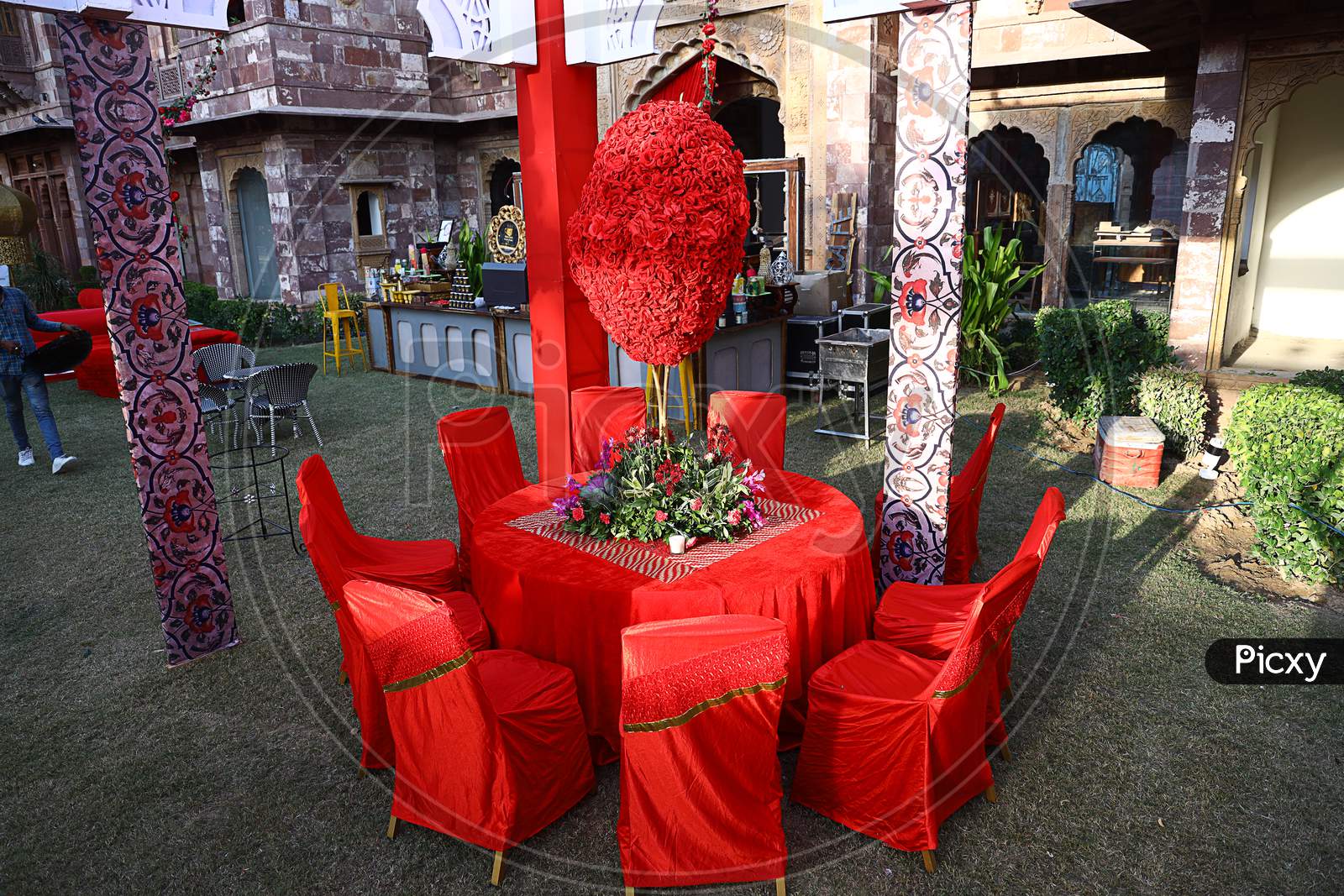 Jodhpur, Rajasthan, India, August 20Th, 2020: Organized Red Table And Chairs With Flowers Ready For The Guests Sitting In Backyard Or Lawn, Decorated Outdoor Wedding Scene