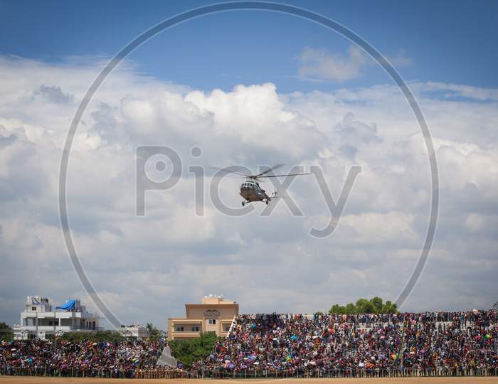 A Beautiful view of an Army Helicopter hovering over a Crowd gathered to witness an Airshow arranged for the Dasara Festival at Mysuru in Karnataka/India.