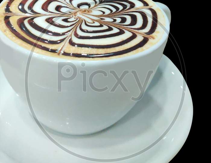 A Cup Of Coffee With Latte Art On Top Of It With Black Background.