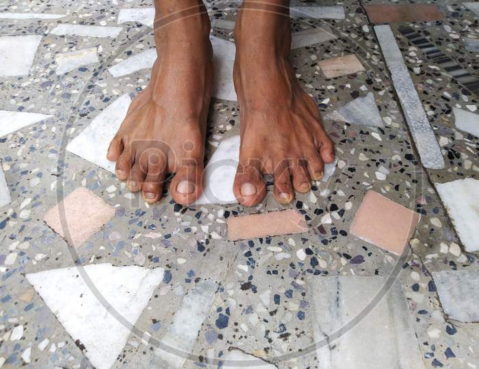 A man standing on floor with his bare foot