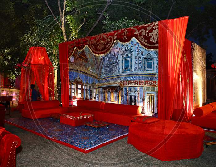 Beautifully Decorated Red Sofas Or Couch Ready For The Guests Sitting At A Wedding Ceremony In Backyard, Night Ceremony Venue, Wedding Event Decor Concept