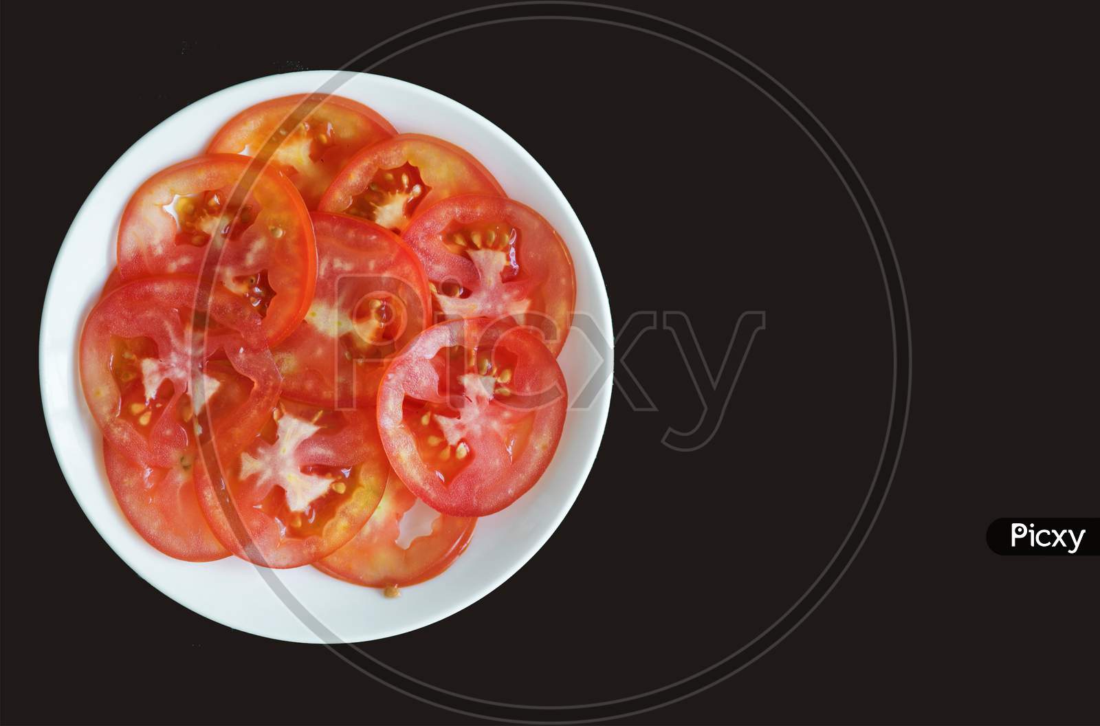 Tomato slices isolated on white bowl, black background