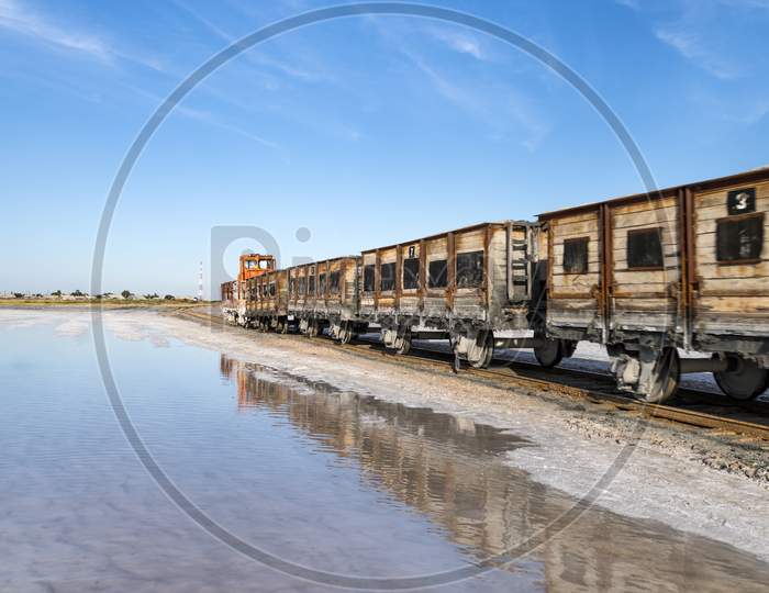Train Travels From Water. Mined Salt In Lake Burlin. Altai. Russia. Bursolith. Old Train Rides On The Railway Laid In The Water Through The Salt Lake.