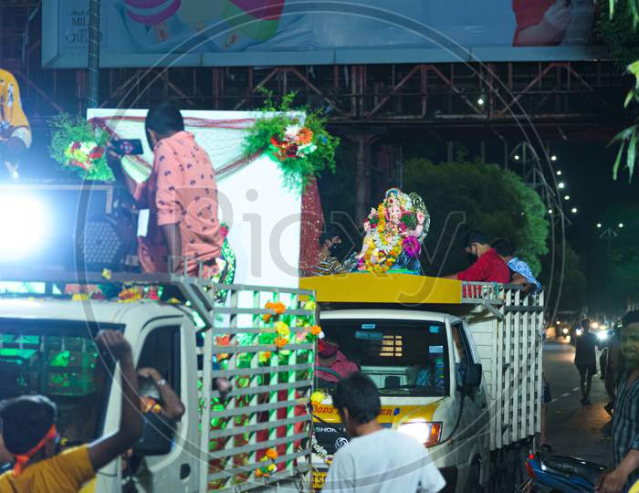 People taking ganesh idol in a vehicle for immersion in tank bund