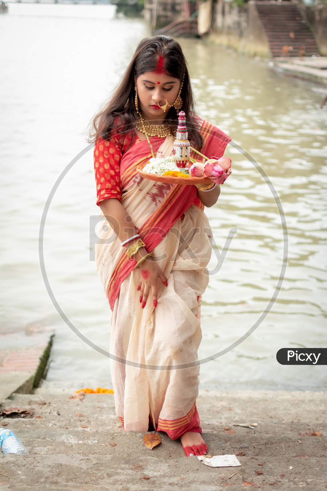 Image of Portrait Of Beautiful Indian Girl Wearing Traditional Indian  Saree, Gold Jewellery And Bangles Holding Plate Of Religious Offering In  Kolkata, India On September 2020-FU032916-Picxy