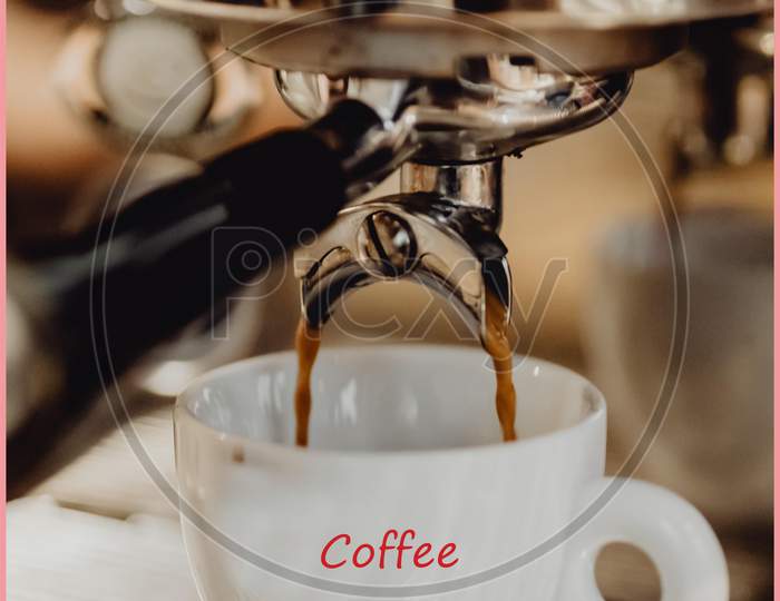 Close-up of coffee pouring from coffee machine into white cup at  restaurant