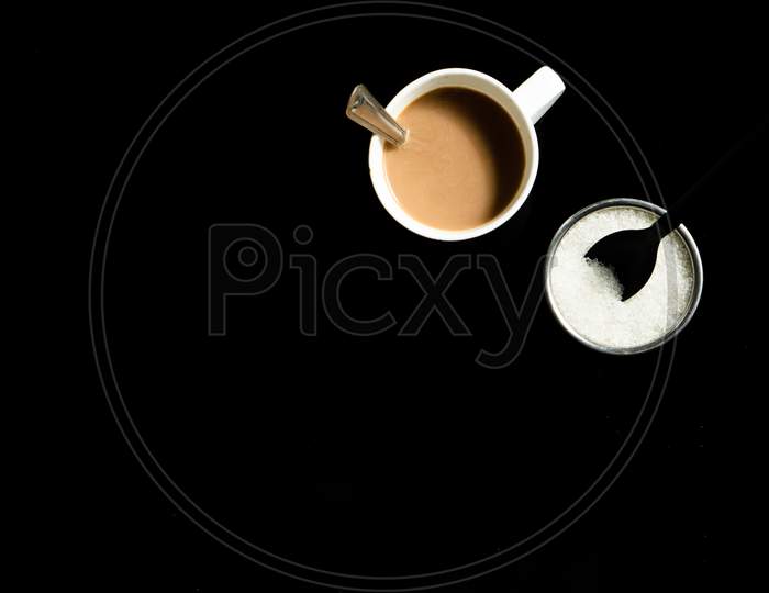 A Cup Of Tea And Sugar On A Black Background