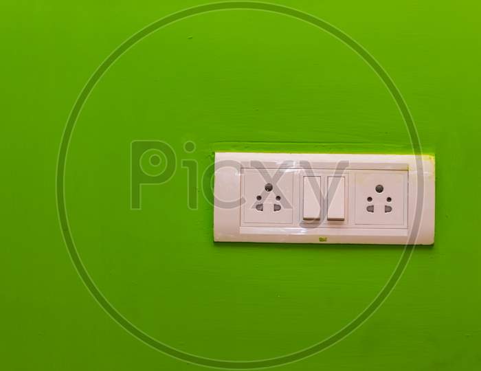 Double Sockets For Electrical Appliances On A Green Wall Background. All Purpose Switch On A Wall Socket.