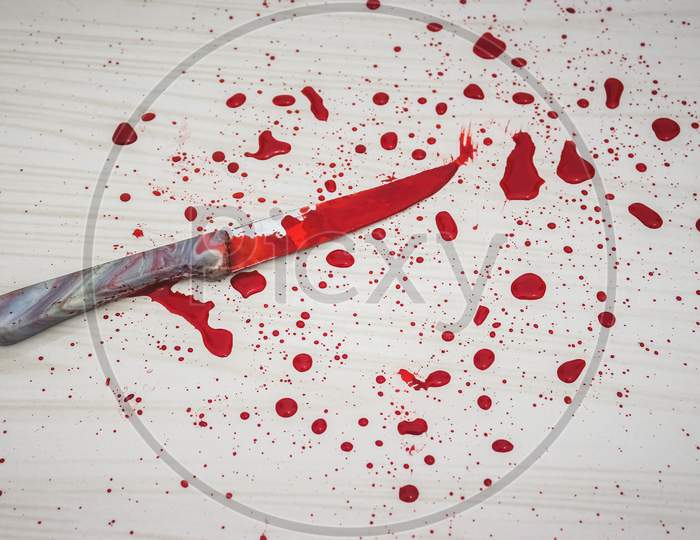 Bloody knife on the floor. knife was found at the scene of the crime. A forensic takes blood samples from the knife. Bloody knife lies on ceramic tiles background. Concept of a domestic killings.