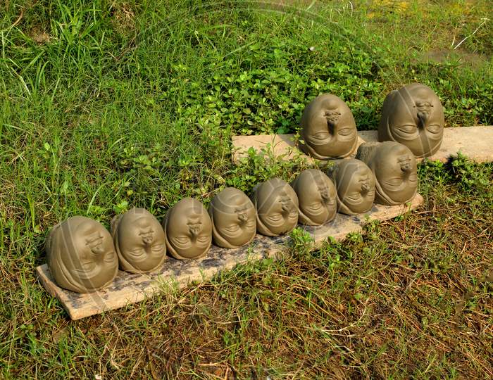 The heads made by clay are drying in Sun light.