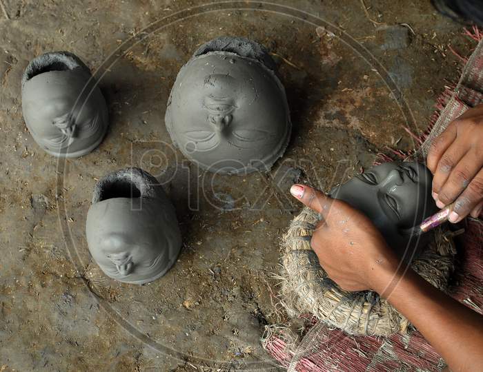 The artisan making clay idols of Devi.
