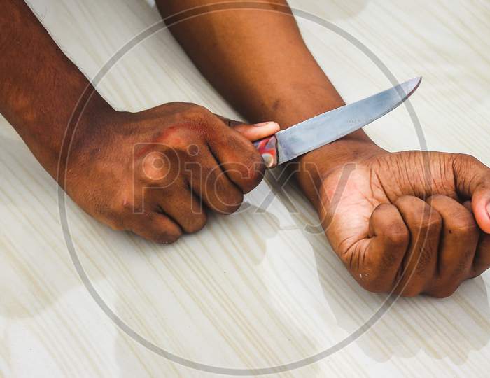 Committed Suicide Concept - Man Want To Commit Suicide By Cutting His Veins With Knife In Isolated On Floor Background. Man Suicide By Knife Cutting A Wrist,Depressed & Sad Love.