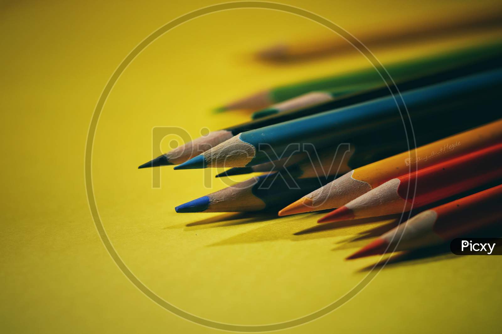 Colourful pencils isolated with yellow background