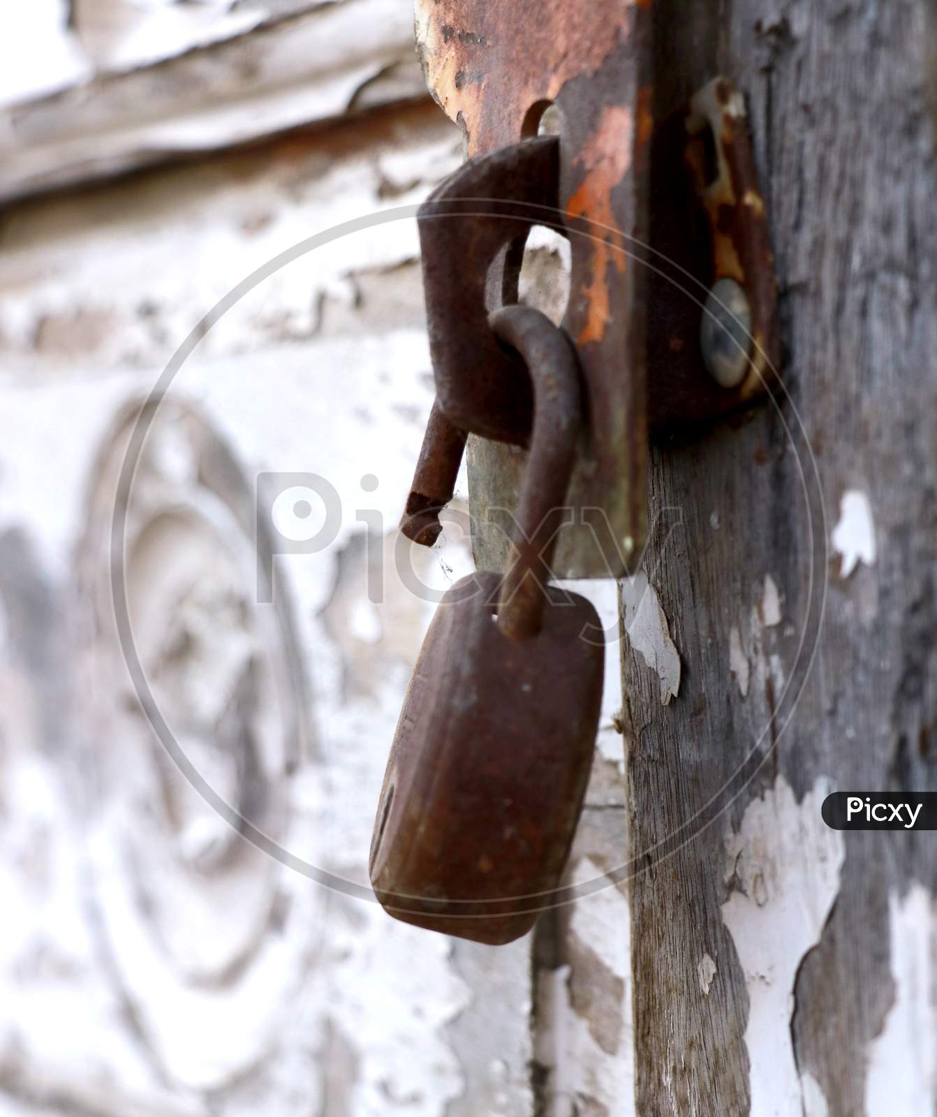 Vertical Shot Of A Weathered Lock On An Ancient Wooden Door During Daylight