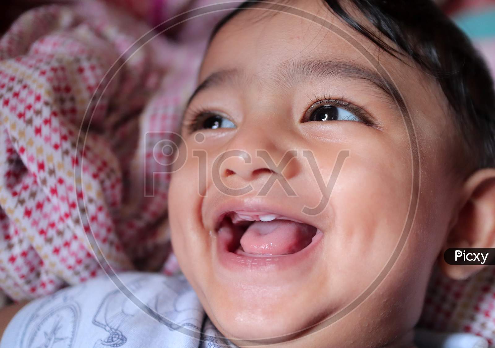 Close Up Photo Of An Indian Baby Boy With First Tooth Erupted And Giving A Gummy Smile