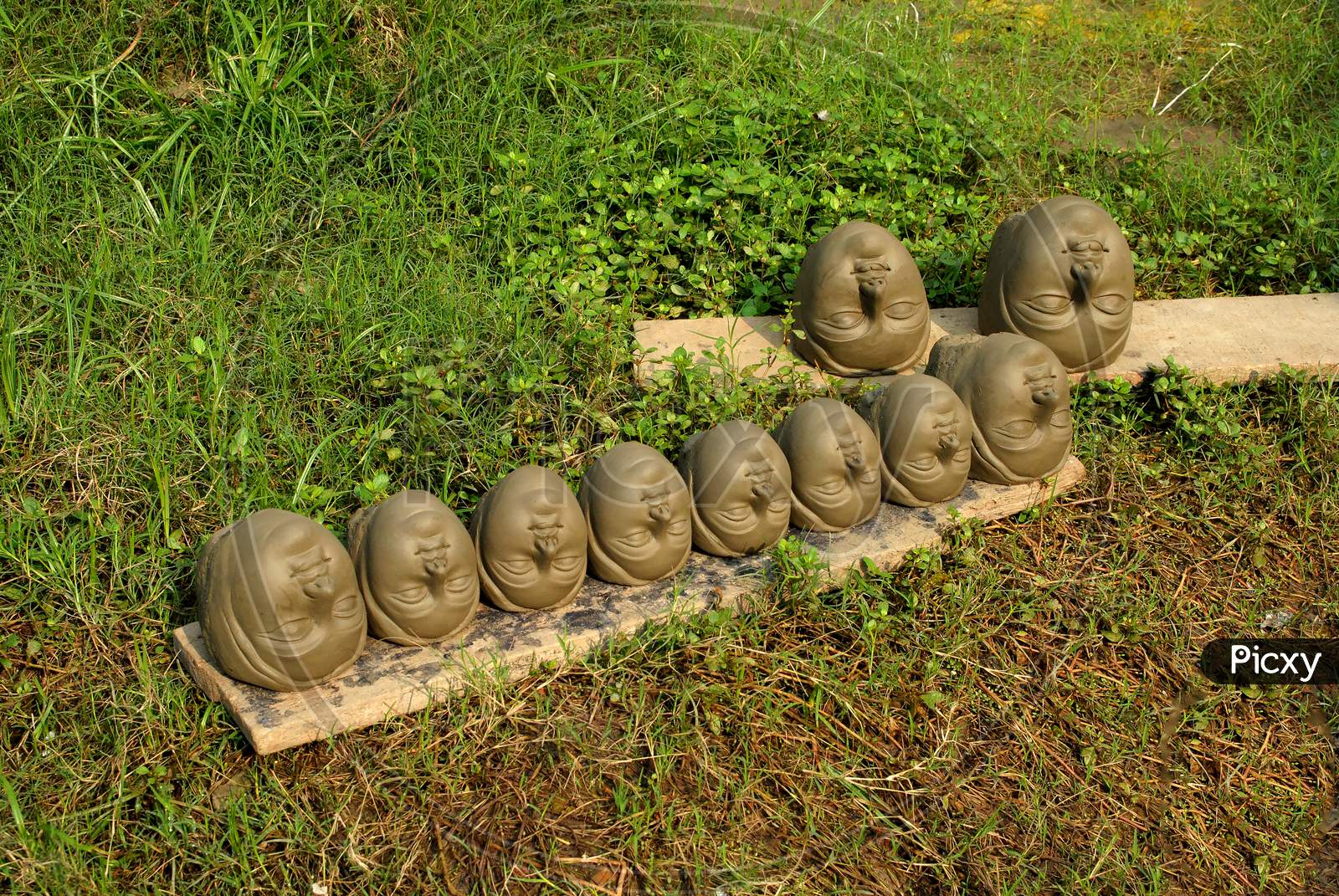 The heads made by clay are drying in Sun light.