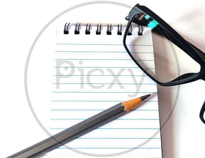 clean notebook, eyeglasses on white background