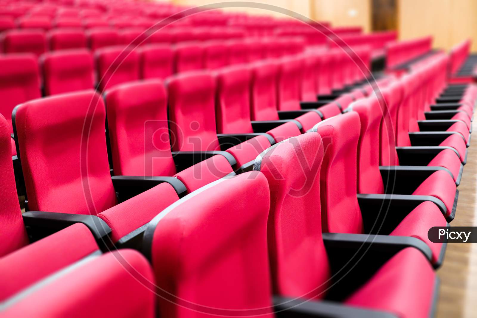 Empty Rows Of Seats Of An Auditorium With Red Reclining Rows Of Seats And False Ceiling Led Lights