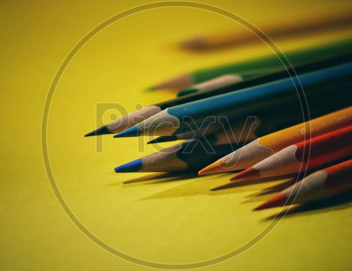 Colourful pencils isolated with yellow background