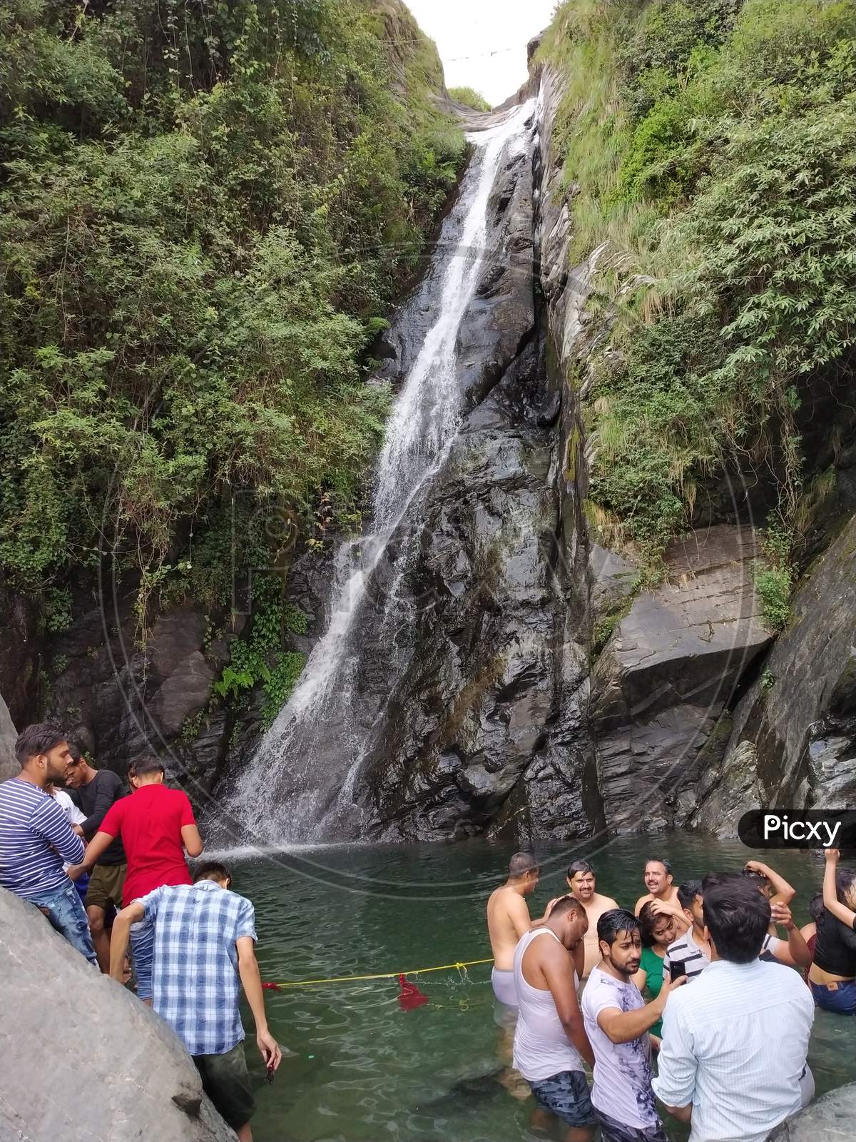 peoples enjoying in beautiful waterfall in India Himalayas mountains Dharamshala Mcleodganj triund Himachal Pradesh