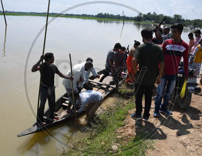 People on a boat move across the flood-affected area, at Jamunamukh  village in Hojai district of Assam on Sept 29,2020