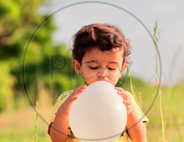 An Indian Boy Pours Air Into The Balloon