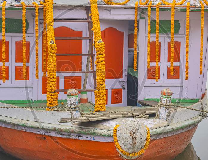 Yellow flower garlands decorates a wooden tourist boat in Varanasi