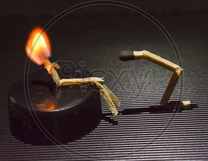 A Miniature Art Of Matchsticks In Form Of A People On Top Of Table.